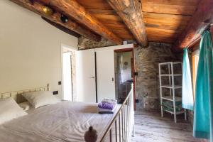 um quarto com uma cama e um tecto de madeira em Casa rústica la Borda de la Munda. em Arsèguel