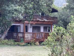 een huis met een groot terras aan de zijkant bij Forest Drive Holiday Home in Natureʼs Valley
