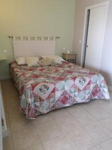 ein Schlafzimmer mit einem Bett mit einer Decke darauf in der Unterkunft Rose Niche in Cavalaire-sur-Mer