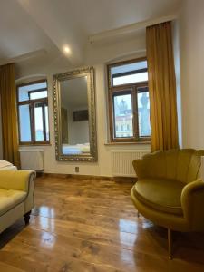 a living room with a couch and a mirror at Atmosféra Rooms & Restaurant in Loket