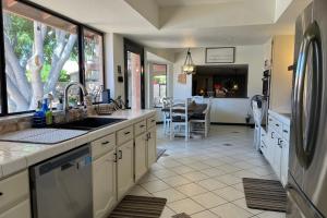 a kitchen with a sink and a refrigerator at The Arrowhead Oasis - hot tub, heated pool, fire pits, backyard games in Glendale