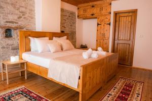 een slaapkamer met een groot houten bed in een kamer bij Porta7 Hotel in Gjirokastër