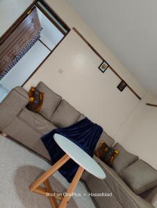 - un salon avec un canapé et une chaise dans l'établissement Rovers Apartment, à Nanyuki