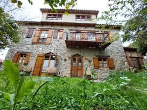 an old stone house with wooden doors and windows at Large Stone Villa with garden. in Khánia