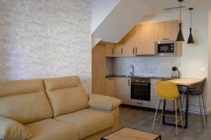 a living room with a couch and a table and a kitchen at Apartamentos Son do Faro Fisterra in Finisterre