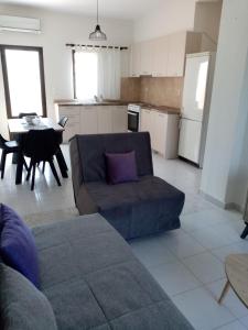 ein Wohnzimmer mit einem Sofa und einem Tisch in der Unterkunft Deaspoina Apartments in Nea Roda
