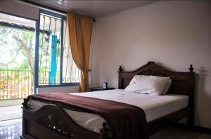 1 dormitorio con cama y ventana grande en Hab doble & baño privado, en Armenia