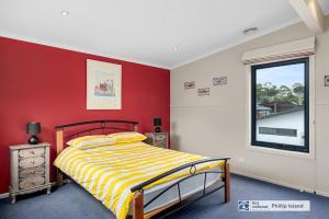 a bedroom with a bed and a red wall at 29 Church Street, Cowes in Cowes
