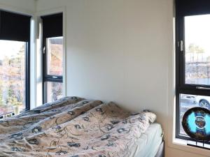 łóżko w pokoju z dwoma oknami w obiekcie Holiday home Søndeled w mieście Søndeled