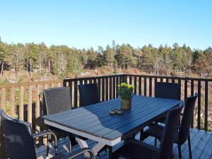 niebieski stół piknikowy na tarasie z krzesłami w obiekcie Holiday home Søndeled w mieście Søndeled