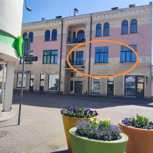 an orange circle in front of a building with flowers at Ventspils apartamenti pie Rātslaukuma in Ventspils