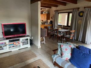 uma sala de estar com televisão e uma sala de jantar em Forest Drive Holiday Home em Natureʼs Valley