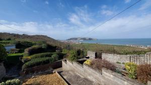 a view of the ocean from a hill at A View With A Room in Penrhyn Bay