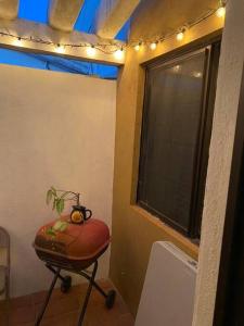 a room with a stool and a window with a plant on it at Casa Gaviotas Art cozy 2 bed house with art studio close to downtown in La Paz