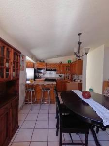 una cocina con mesa y algunas sillas. en Casa Gaviotas Art cozy 2 bed house with art studio close to downtown en La Paz