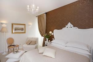- une chambre avec un lit blanc et un lustre dans l'établissement Daplace - HQH Colosseo, à Rome