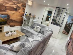 een woonkamer met een bank en een tafel bij Sahara & Joshua tree / calme & chaud in Montgeron
