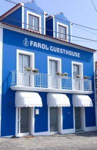 英雄港的住宿－Farol Guesthouse，蓝色和白色的建筑,设有白色阳台