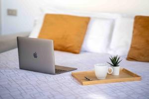 een laptop op een bed met een dienblad en een kopje koffie bij [DUOMO 2 MINUTI A PIEDI] Vista mozzafiato 5 stelle in Milaan