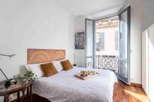 Un dormitorio con una cama grande y una bandeja. en [DUOMO 2 MINUTI A PIEDI] Vista mozzafiato 5 stelle en Milán