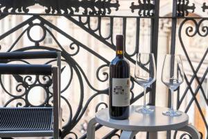 een fles wijn zittend op een tafel met twee glazen bij [DUOMO 2 MINUTI A PIEDI] Vista mozzafiato 5 stelle in Milaan