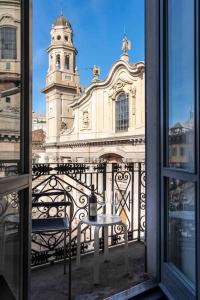 een raam met een tafel en een gebouw met een klokkentoren bij [DUOMO 2 MINUTI A PIEDI] Vista mozzafiato 5 stelle in Milaan