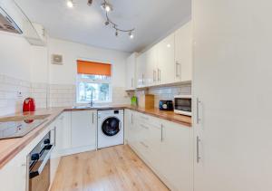 謝林漢姆的住宿－3 Hilbre Court，厨房配有白色橱柜和洗衣机。
