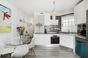 a kitchen with a glass table and white cabinets at yojalavi sunrise in Candelaria