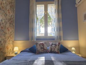 a bedroom with a bed with two pillows and a window at Le Casette in Santa Flavia