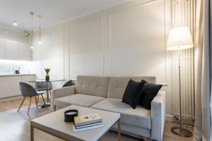 a living room with a couch and a table at Golden Apartments Warsaw - Mennica Residence in Warsaw