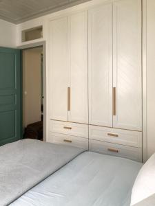 パノルモス・スコペロスにあるGiasemi house with sea viewの白いキャビネットとベッド付きのベッドルーム1室