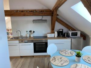 a kitchen with white cabinets and a blue table and chairs at Lieblingsplatz an der Lahn in Weinbach +7 photos
