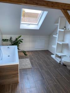 a bathroom with a sink and a toilet and a skylight at Lieblingsplatz an der Lahn in Weinbach