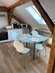 a kitchen with a blue table and chairs at Lieblingsplatz an der Lahn in Weinbach