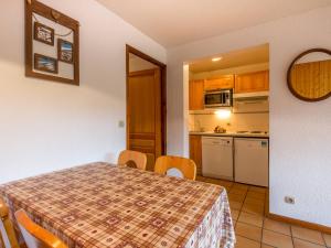 a kitchen and a dining room with a table and chairs at Charmant appartement proche ski et village, animaux admis - FR-1-437-31 in La Clusaz