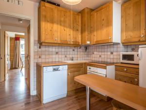 uma cozinha com armários de madeira e uma máquina de lavar louça branca em Appartement La Clusaz, 4 pièces, 8 personnes - FR-1-437-34 em La Clusaz