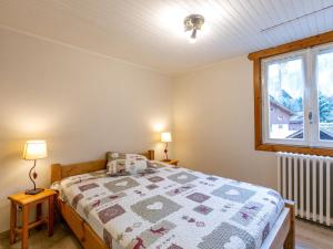een slaapkamer met een bed met een quilt bij Appartement La Clusaz, 3 pièces, 6 personnes - FR-1-437-37 in La Clusaz