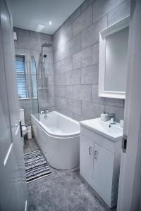 Baño blanco con bañera y lavamanos en Halifax Haven – Simple2let Serviced Apartments en Halifax