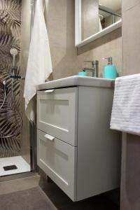 een witte badkamer met een wastafel en een douche bij Lalla Home in Bari