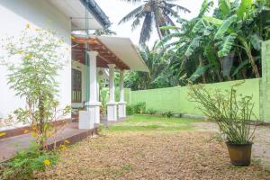 a porch of a house with a green wall at Greenway Apartment in Galle