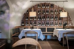 a restaurant with two tables and a wall of bottles at Hotel Weingut Stroblhof in Appiano sulla Strada del Vino