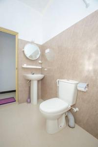 a bathroom with a toilet and a sink and a mirror at Greenway Apartment in Galle
