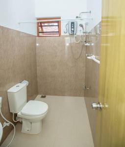 e bagno con servizi igienici bianchi e doccia. di Greenway Apartment a Galle