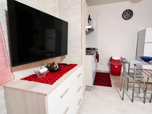 sala de estar con TV de pantalla plana grande en Tropea Comfort Room en Tropea
