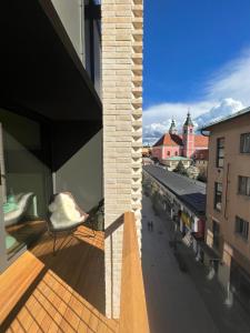 a balcony with a chair and a view of a city at Castle View Luxury Suite in Ljubljana