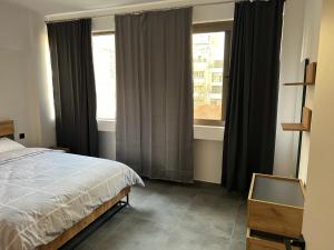Schlafzimmer mit einem Bett und einem Fenster in der Unterkunft Exclusive ladadika apartment 2 in Thessaloniki