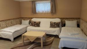 Habitación pequeña con 2 camas y mesa. en Kitti Panzió en Mogyoród