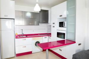 uma cozinha com armários brancos e bancadas vermelhas em Apartamento Completo Clara Campoamor Carboneras em Carboneras