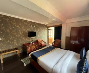 een slaapkamer met een bed en een tv aan de muur bij The Di-Lac Retreat in Gangtok