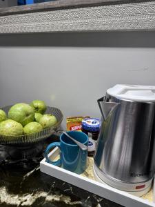 a kitchen counter with a coffee maker and a bowl of fruit at Queen Size Studio in Solinea, Cebu City in Cebu City